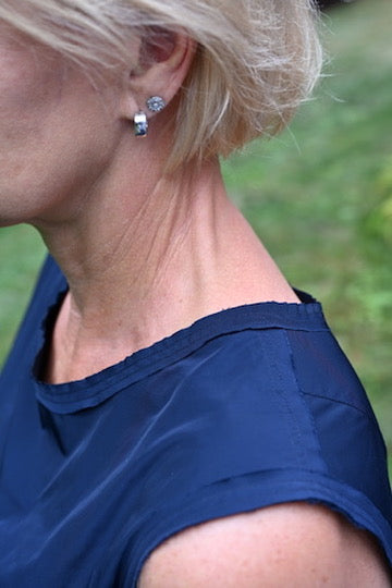 A close-up view of the raw, frayed neckline and armholes of the Dana